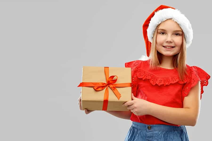 Enfant portant un cadeau et un bonnet pour Noël