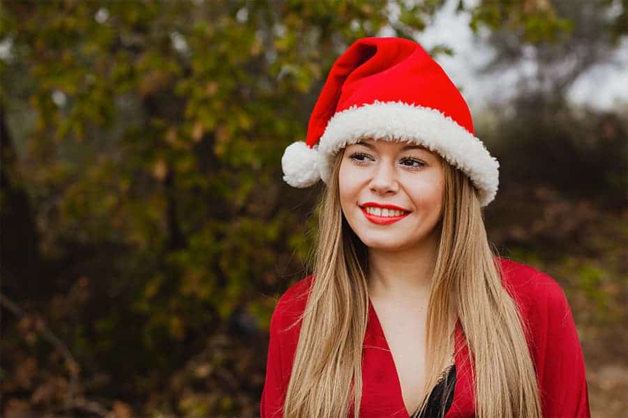 Femme dans la nature portant un bonnet de Noël rouge